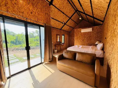 a bedroom with a bed and a couch in it at Tavana Residence in Ban Na Bon