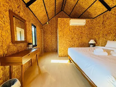 a bedroom with a bed and a desk in a room at Tavana Residence in Ban Na Bon