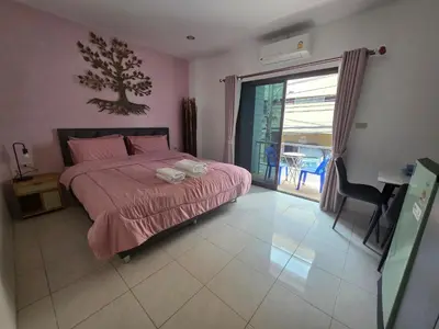 a bedroom with a bed and a desk and a window at Chokdee rooms kata in Kata Beach