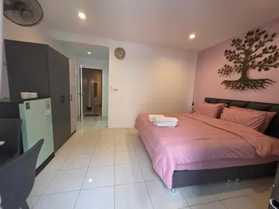 a bedroom with a bed with a tree on the wall at Chokdee rooms kata in Kata Beach