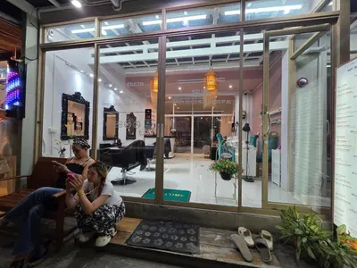 two people sitting in front of a store window at Chokdee rooms kata in Kata Beach