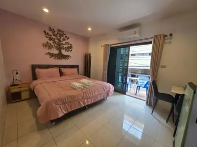 a bedroom with a bed and a sliding glass door at Chokdee rooms kata in Kata Beach