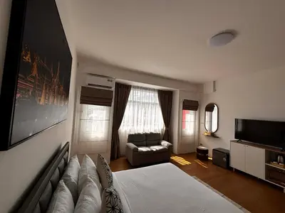a bedroom with a bed and a couch and a television at Phuket gateway inn in Kathu