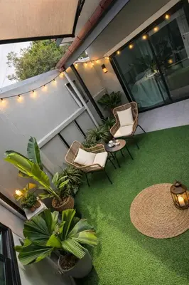 a balcony with chairs and a table and plants at Phuket sun n soul House in Ban Tha Rua
