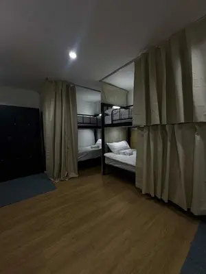a room with two bunk beds and a wooden floor at Top Hotel Patong in Patong Beach