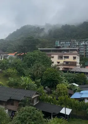 a city with buildings and trees and a mountain at Top Hotel Patong in Patong Beach