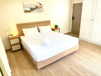 a bedroom with a large bed with white sheets at Top Hotel Patong in Patong Beach