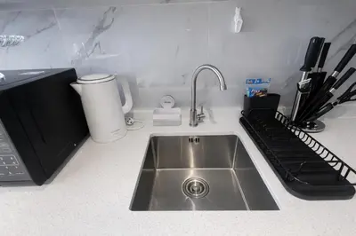 a kitchen counter with a stainless steel sink and a mixer at Новые апартаменты в Utopia Naiharn in Rawai Beach