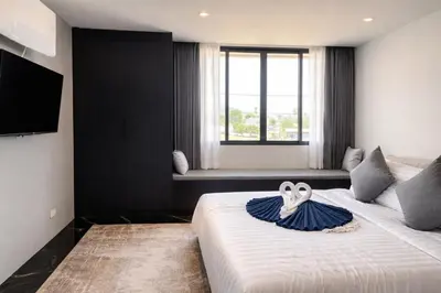 a hotel room with a bed with two swans on it at Новые апартаменты в Utopia Naiharn in Rawai Beach
