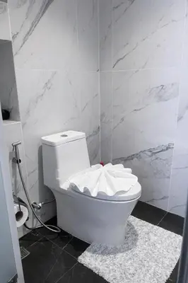 a white toilet in a bathroom with marble walls at Новые апартаменты в Utopia Naiharn in Rawai Beach