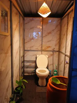 a bathroom with a toilet with a marble wall at Kalaland in Patong Beach