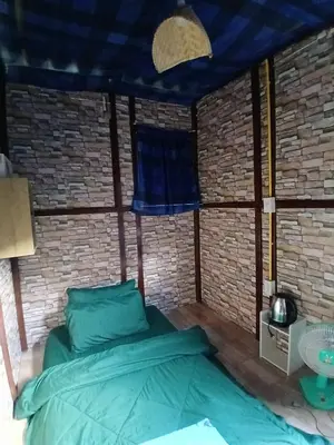 a bed in a room with a brick wall at Kalaland in Patong Beach