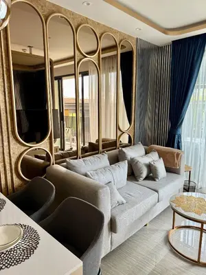 a living room with a couch and some windows at Stylish Apartments in a New Boutique Complex in the Laguna in Laguna Phuket