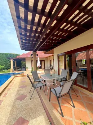 a patio with a table and chairs next to a pool at Luxury 3-bedroom villa with pool in Rawai in Rawai Beach