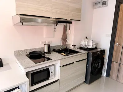 a small kitchen with a stove and a sink at FAMILY HOMES Panoramic Pool View Studio in Mai Khao CB-706 in Ban Mai Salae