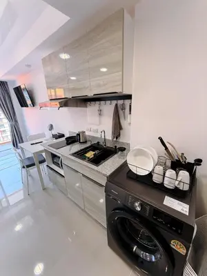 a kitchen with a washer and a stove top oven at FAMILY HOMES Panoramic Pool View Studio in Mai Khao CB-706 in Ban Mai Salae