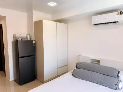 a small bedroom with a refrigerator and a bed at FAMILY HOMES Panoramic Pool View Studio in Mai Khao CB-706 in Ban Mai Salae
