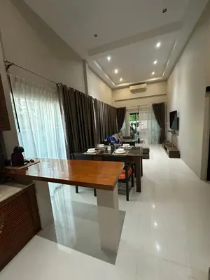 a living room with a dining table and a living room at Villa Bang Tao Ananda Lake View in Ban Pak Lak