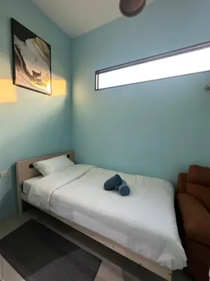 a bedroom with a bed and a window and a chair at Villa Bang Tao Ananda Lake View in Ban Pak Lak