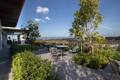 a patio with a table and chairs and trees at Canvas 1112 TwoBedroom Residence in Phuket Town