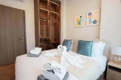 a bedroom with a white bed with towels on it at Canvas 1112 TwoBedroom Residence in Phuket Town