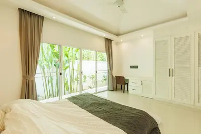 a bedroom with a bed and a large window at Peaceful Villa 12 mins to Bangtao & Layan Beach in Ban Pak Lak