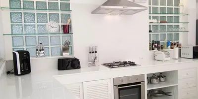 a white kitchen with a counter top with a stove at Mango Villa in Ban Pa Khlok