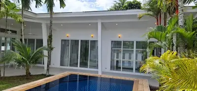 a house with a swimming pool in front of it at Mango Villa in Ban Pa Khlok