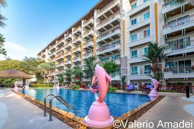a hotel swimming pool with pink flamingos in front of a building at Patong Center - Pool Gym Near Bangla Rd in Patong Beach