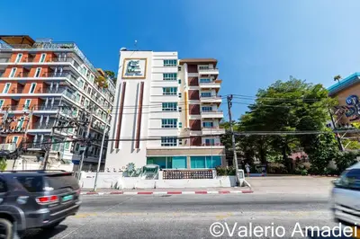 a tall white building with a clock on it at Patong Center - Pool Gym Near Bangla Rd in Patong Beach