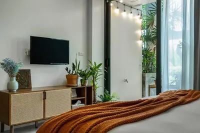 a bedroom with a bed with a television on the wall at Spacious studio with big patio ! in Rawai Beach