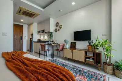 a bedroom with a bed with an orange blanket at Spacious studio with big patio ! in Rawai Beach