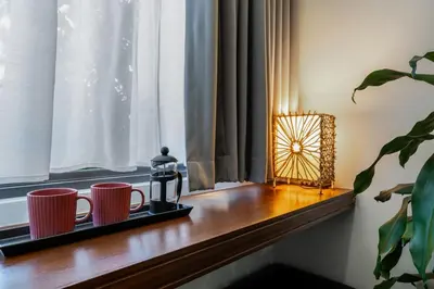 two coffee mugs on a wooden window sill with a candle at Spacious studio with big patio ! in Rawai Beach