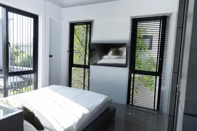 a bedroom with two windows and a bed in it at Villa Wallaya with pool in Bang Tao in Ban Pak Lak