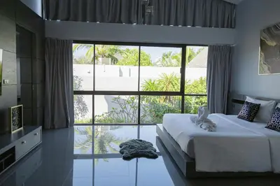a bedroom with a bed and a large window at Villa Wallaya with pool in Bang Tao in Ban Pak Lak