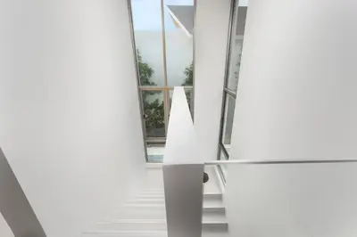 a staircase in a house with white walls and a window at Taimana Luxury 3BR Private Pool Villa at LuxPride in Ban Phak Chit