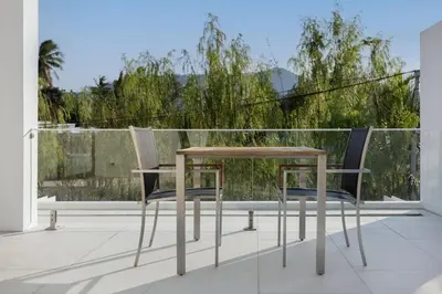 a table and two chairs sitting on a balcony at Taimana Luxury 3BR Private Pool Villa at LuxPride in Ban Phak Chit