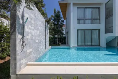 a swimming pool in front of a house at Taimana Luxury 3BR Private Pool Villa at LuxPride in Ban Phak Chit