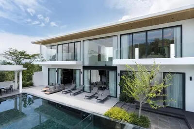 an exterior view of a house with a swimming pool at Menara Luxury 4 Bedroom Private Pool Villa BangTao in Ban Phak Chit