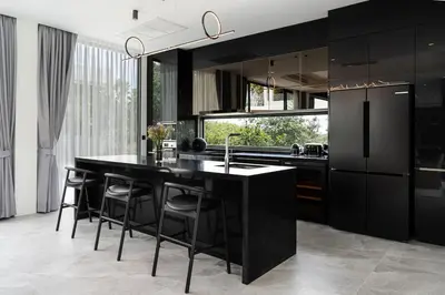 a kitchen with black cabinets and a kitchen island with bar stools at Menara Luxury 4 Bedroom Private Pool Villa BangTao in Ban Phak Chit