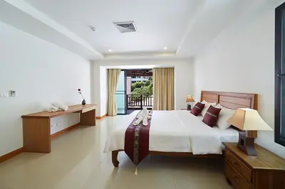a bedroom with a large bed and a window at Surin Sabai in Surin Beach