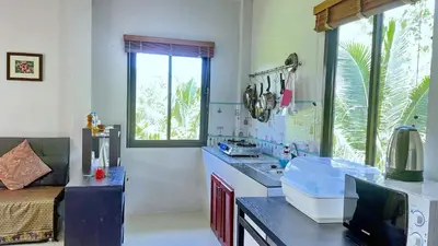 a kitchen with a counter with a sink and a window at Abbas House by Swiss Chalet, 2-room Cottages in Krabi town
