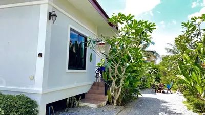 a white house with stairs leading to the backdoor at Abbas House by Swiss Chalet, 2-room Cottages in Krabi town