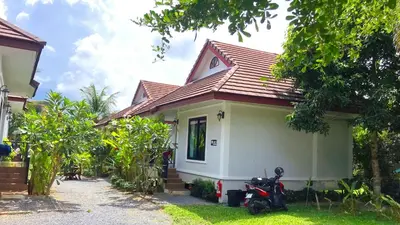 a house with a motorcycle parked in front of it at Abbas House by Swiss Chalet, 2-room Cottages in Krabi town
