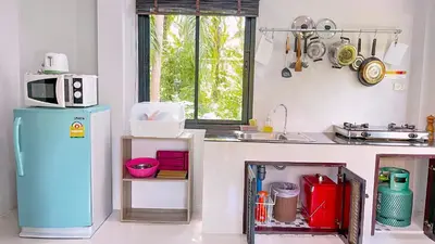 a kitchen with a blue refrigerator and a microwave at Abbas House by Swiss Chalet, 2-room Cottages in Krabi town