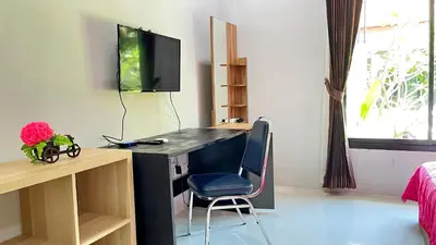 a room with a desk with a monitor and a chair at Abbas House by Swiss Chalet, 2-room Cottages in Krabi town