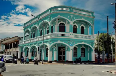 a blue and white building on a city street at xx GO INN Phuket Old Town in Phuket Town