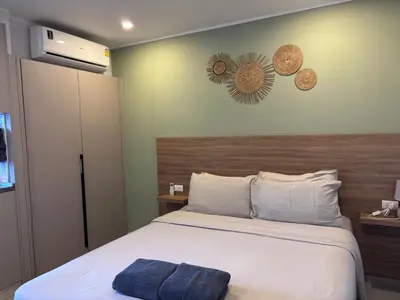 a bedroom with a bed with a wooden headboard at Woodbridge Property at Tower Chalong in Ban Klang