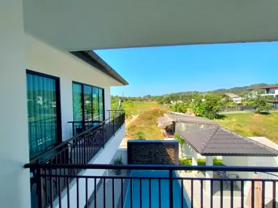 a balcony with a view of a yard at Jitvirat Pool Villa in Ban Nong Chaeng