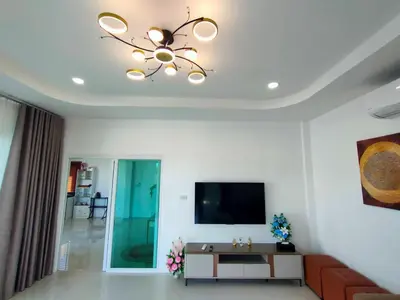 a living room with a television and a chandelier at Jitvirat Pool Villa in Ban Nong Chaeng